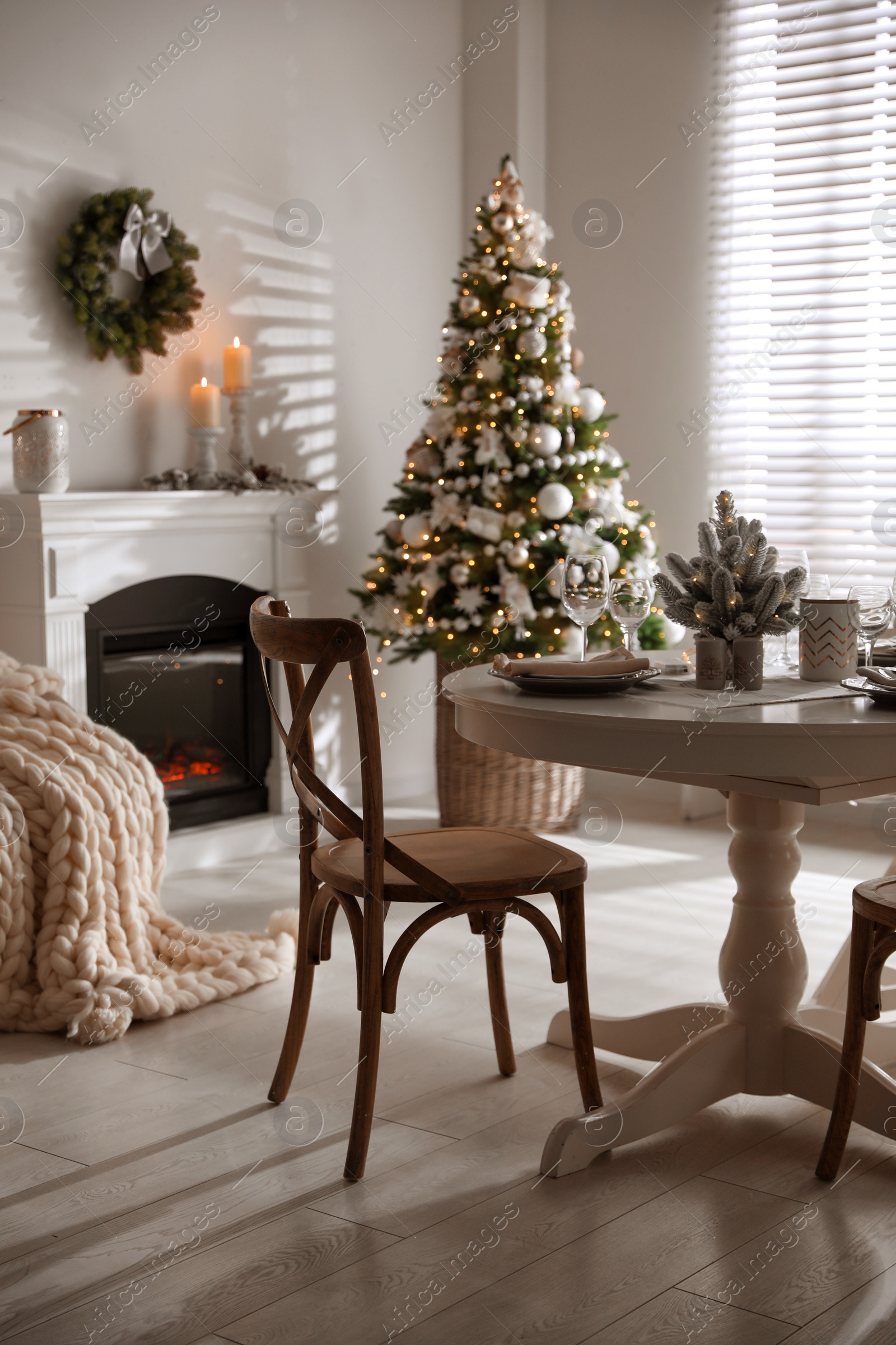 Photo of Festive table setting and beautiful Christmas decor in living room. Interior design