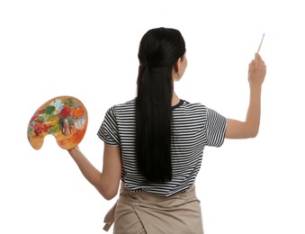 Photo of Young woman drawing with brush on white background, back view