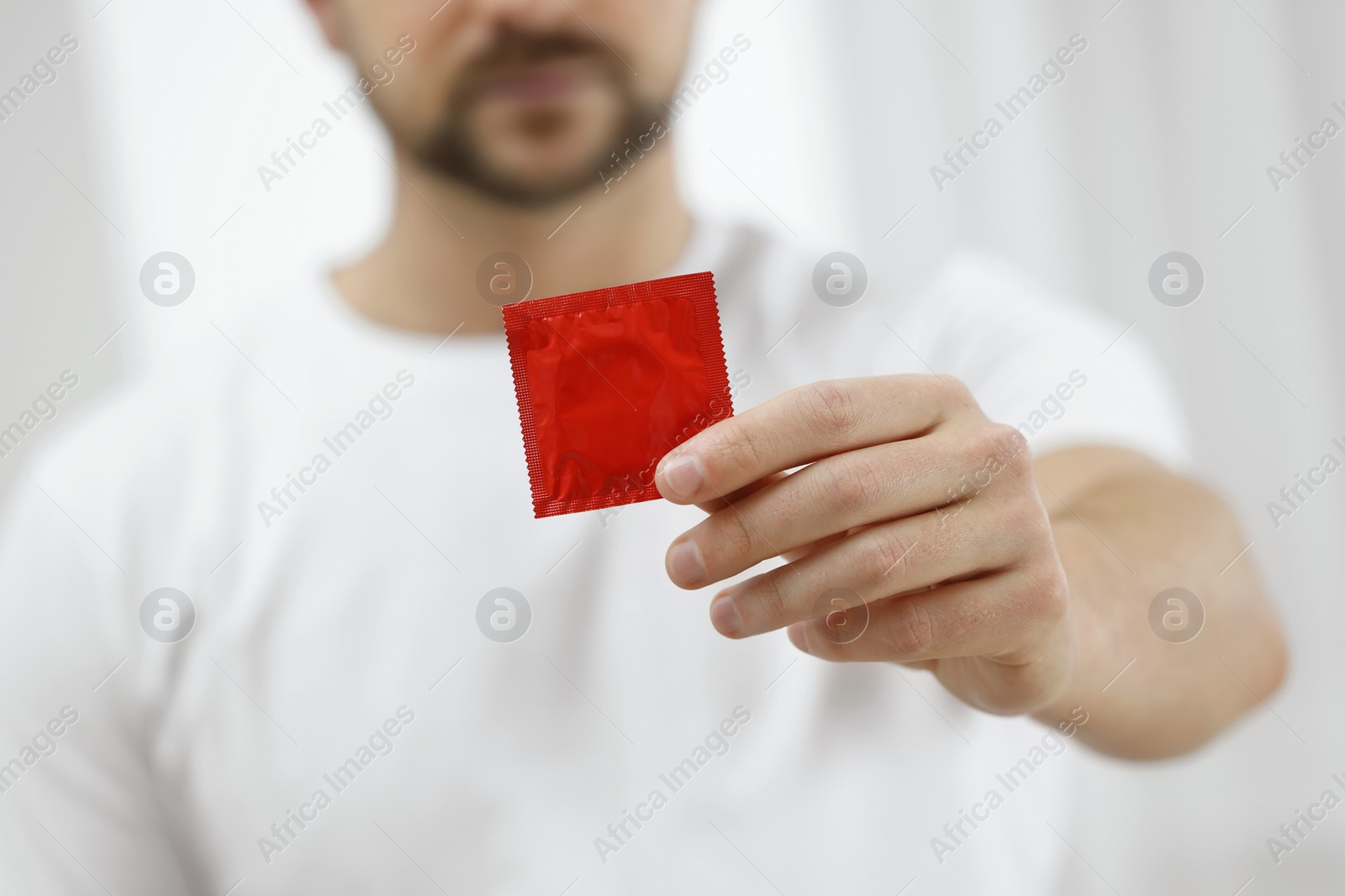 Photo of Closeup view of man showing pack with condom