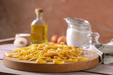 Board with homemade pasta on wooden table