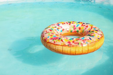 Photo of Inflatable ring floating on water in above ground swimming pool outdoors