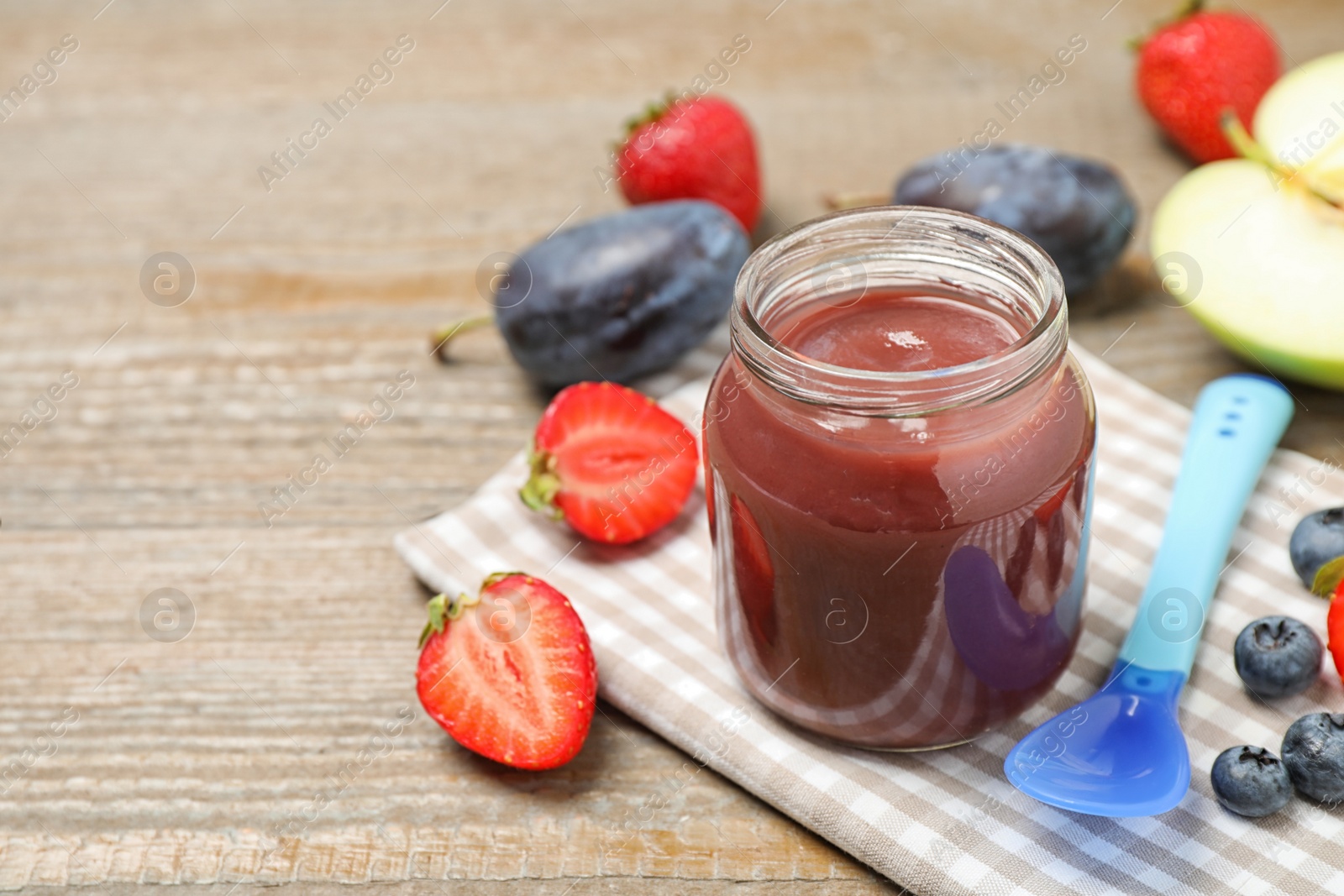 Photo of Healthy baby food and fresh ingredients on wooden table. Space for text