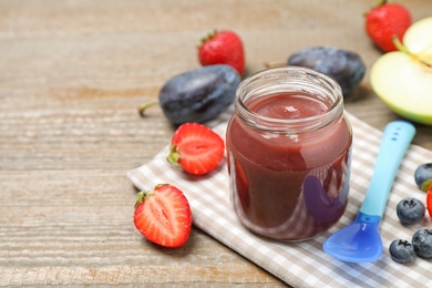 Healthy baby food and fresh ingredients on wooden table. Space for text