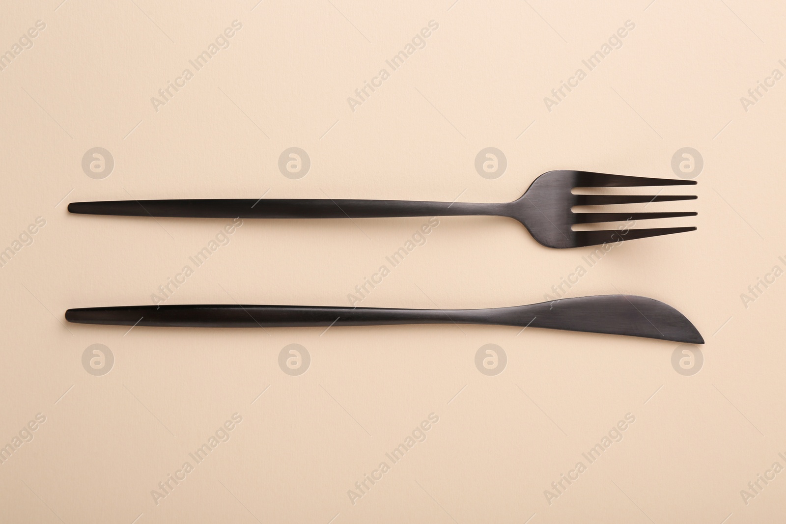 Photo of Stylish cutlery on beige table, top view