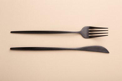 Photo of Stylish cutlery on beige table, top view