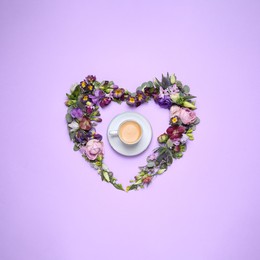 Beautiful heart made of different flowers and coffee on violet background, flat lay
