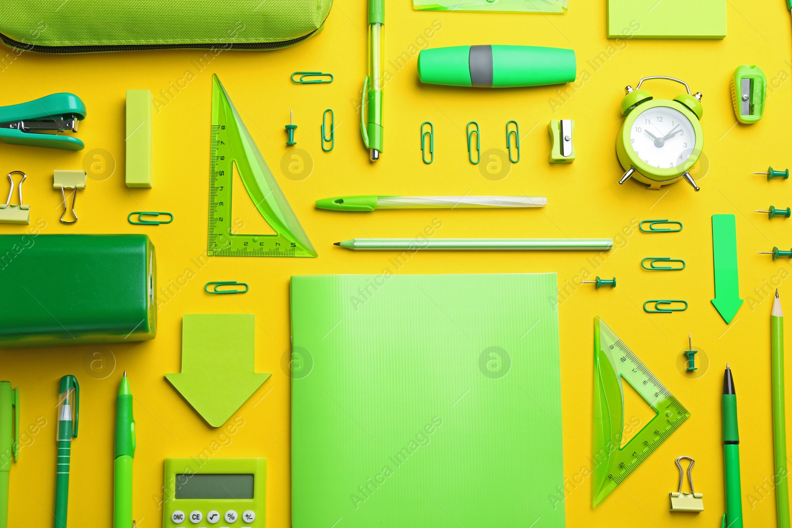 Photo of Green school stationery on yellow background, flat lay