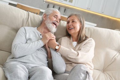 Affectionate senior couple relaxing on sofa at home