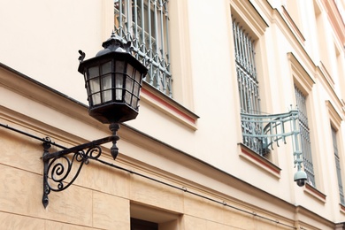 Photo of Vintage street lamp on wall of big building