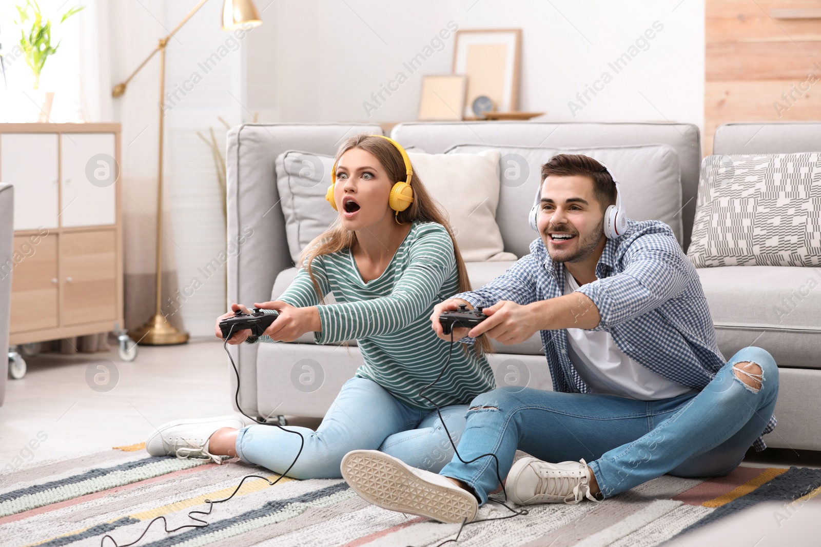 Photo of Emotional young couple playing video games at home