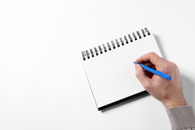 Photo of Man with pen and empty notepad on white background, top view. Space for text