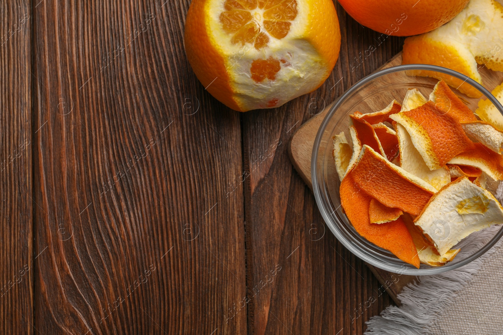 Photo of Dry peels and oranges on wooden table, flat lay. Space for text