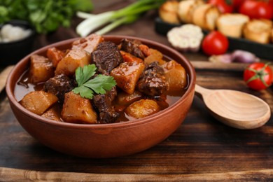 Photo of Delicious beef stew with carrots, parsley and potatoes, closeup