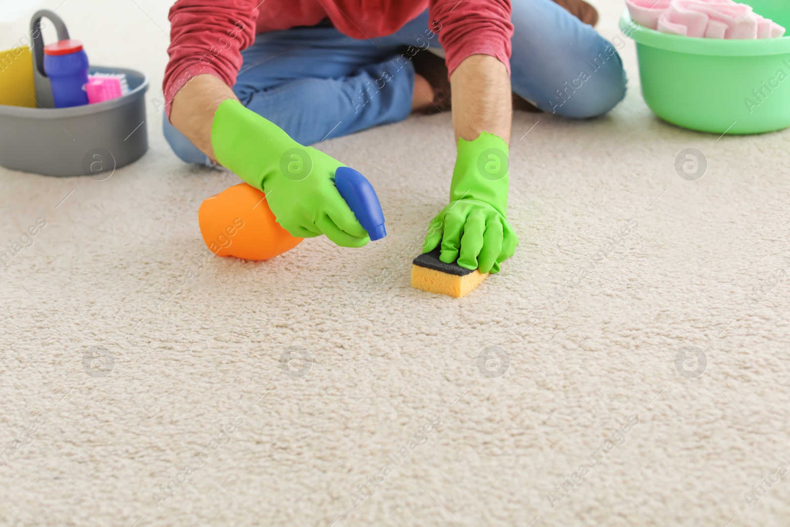 Photo of Young man cleaning carpet at home