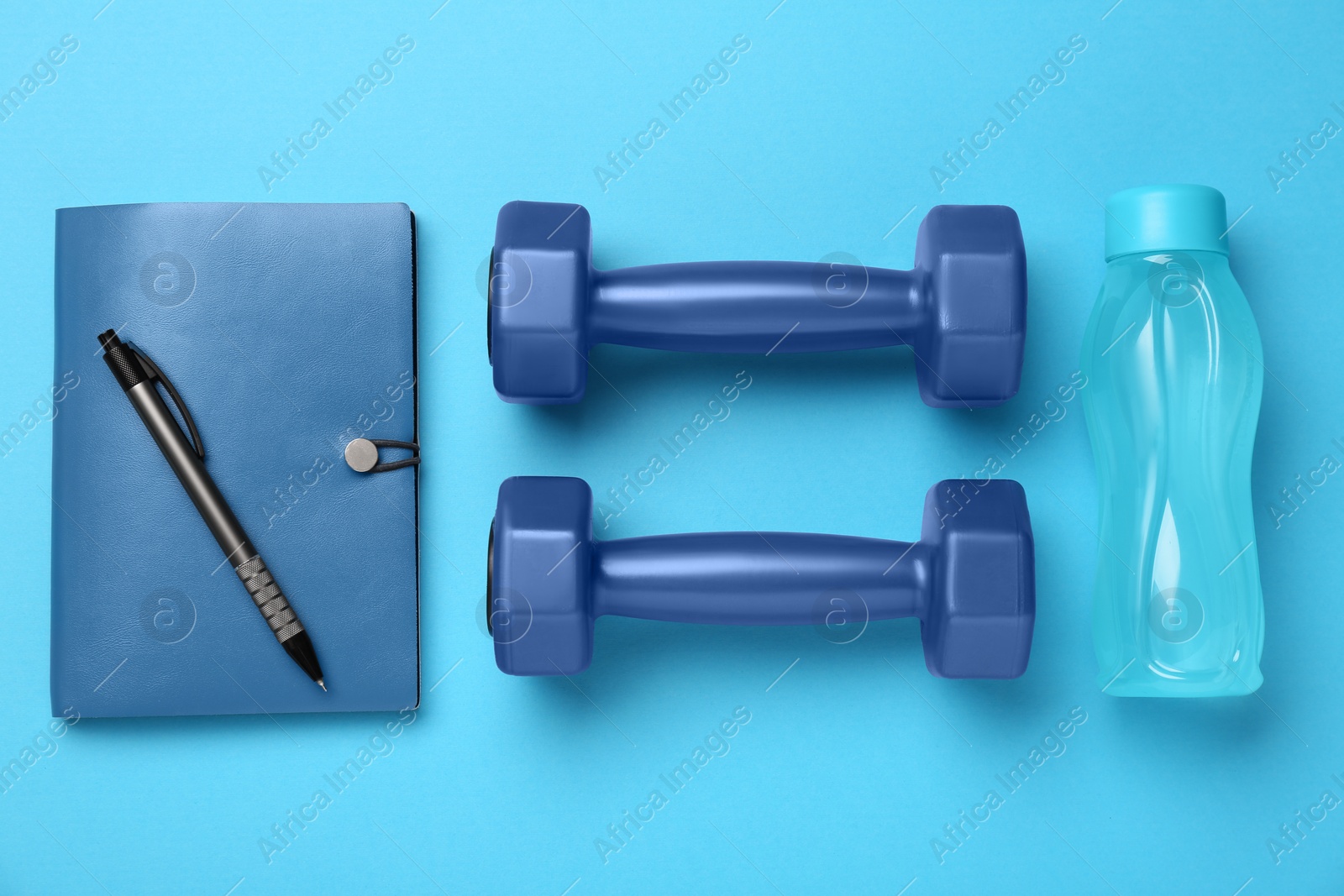 Photo of Flat lay composition with dumbbells on light blue background