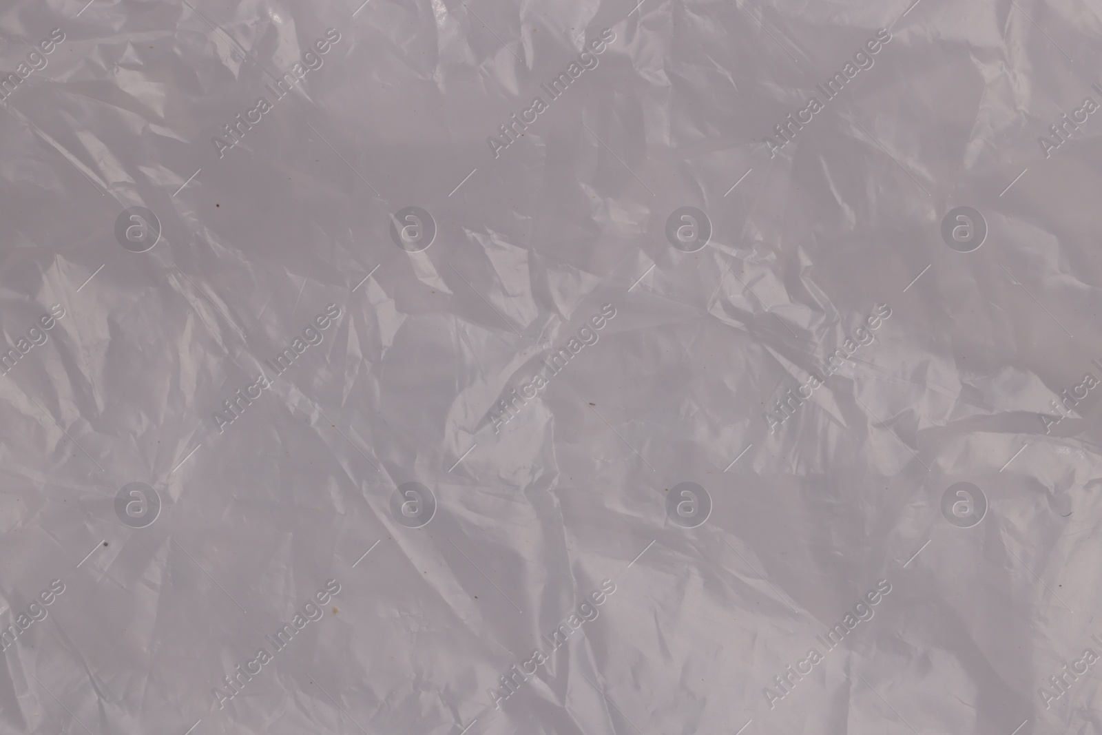 Photo of Crumpled transparent plastic bag as background, top view