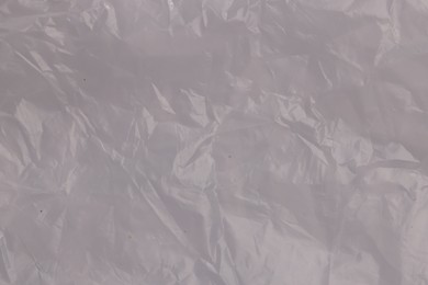 Photo of Crumpled transparent plastic bag as background, top view