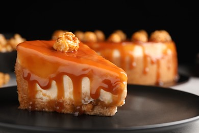 Piece of delicious cake with caramel and popcorn on plate, closeup