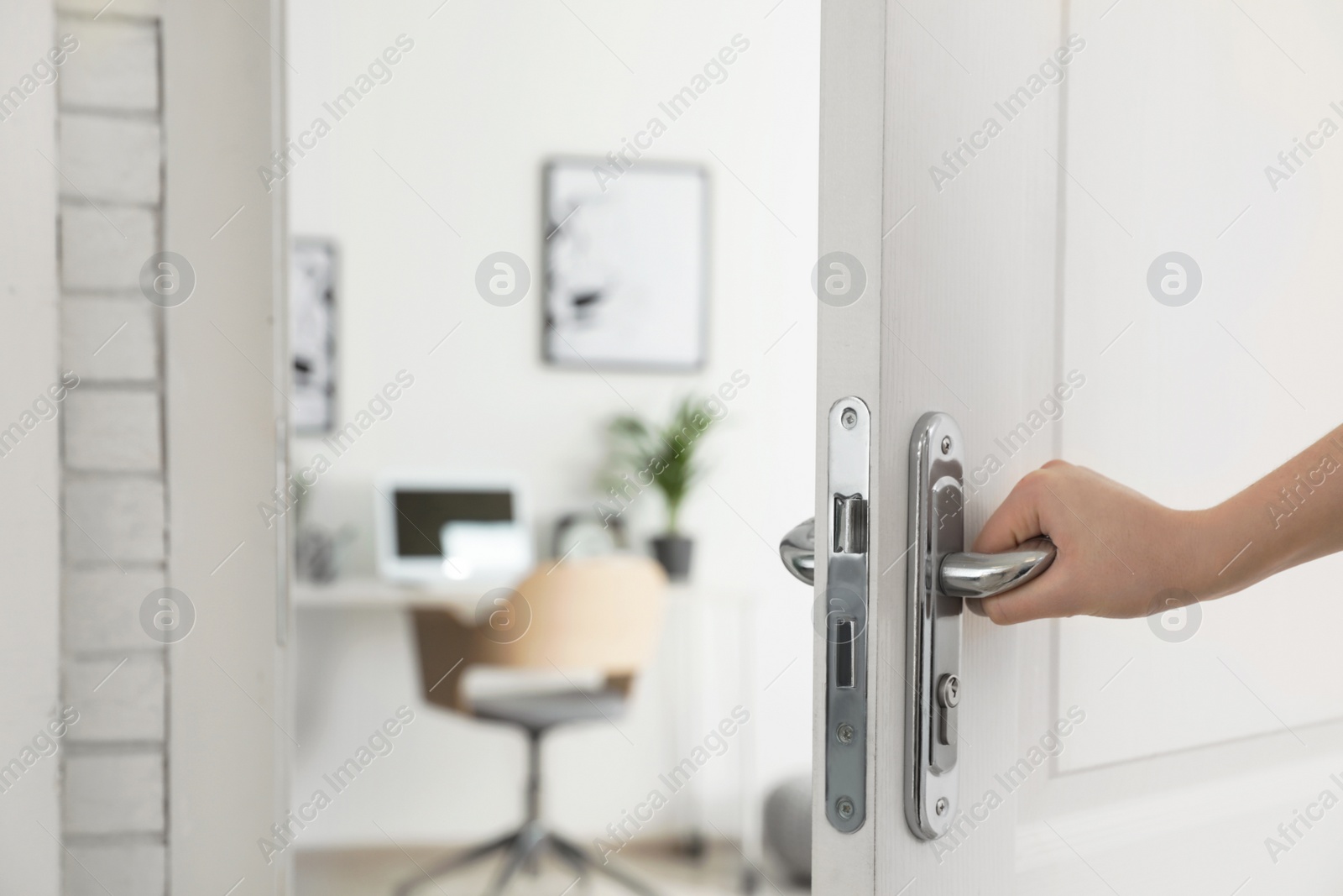 Photo of Woman opening door to stylish room, closeup. Interior design