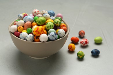 Photo of Ceramic bowl with delicious candies on grey table, closeup. Cooking utensil