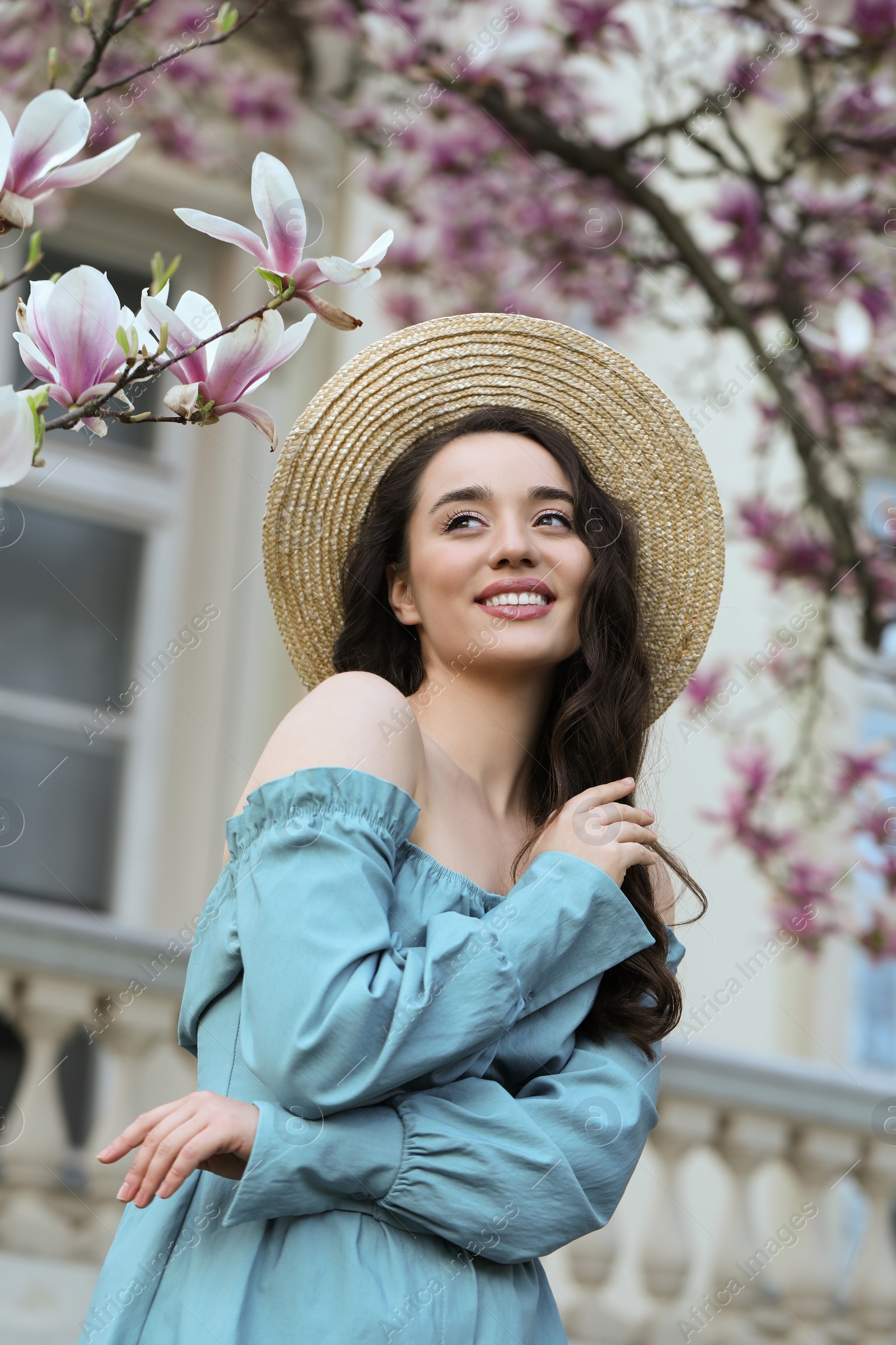 Photo of Beautiful woman near blossoming magnolia tree on spring day