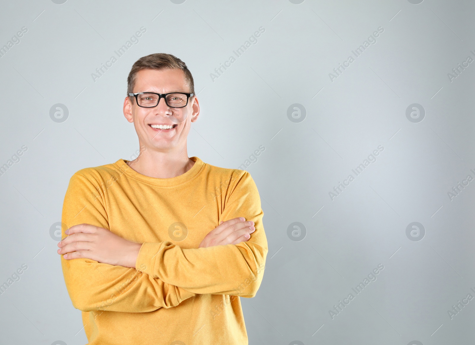 Photo of Man in stylish yellow sweatshirt on grey background, space for text