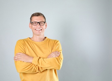 Photo of Man in stylish yellow sweatshirt on grey background, space for text