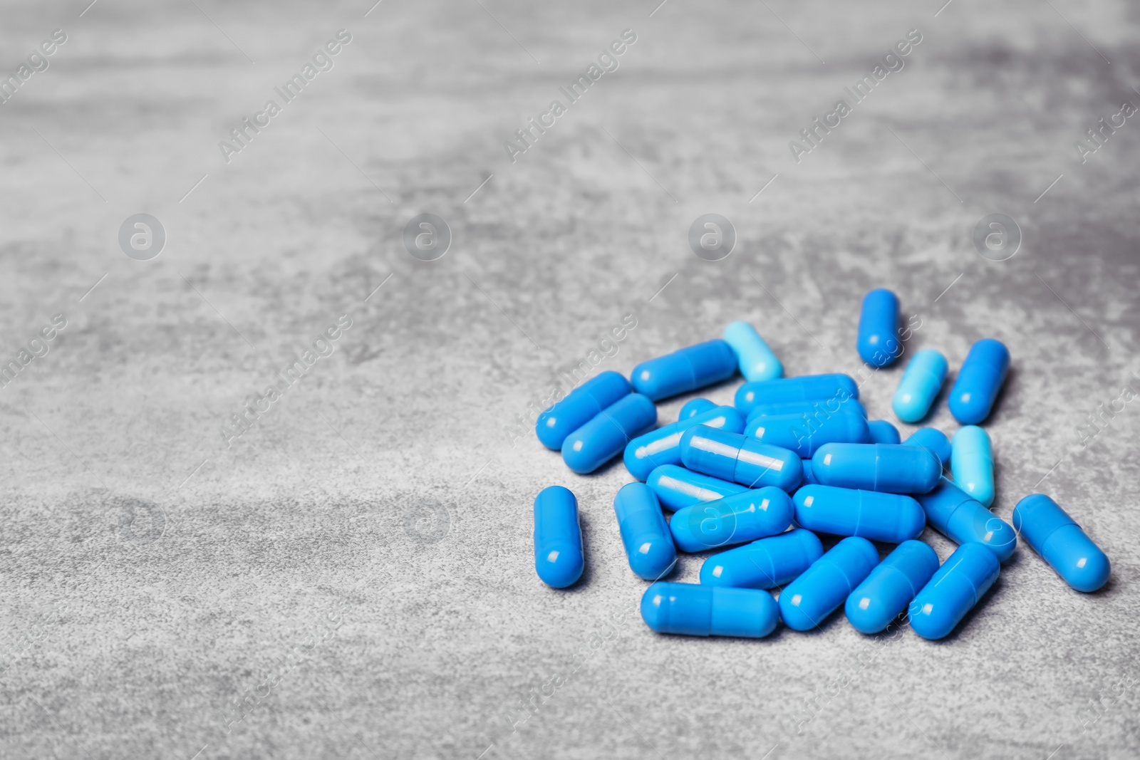 Photo of Blue capsules on grey background