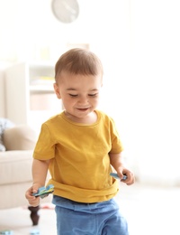 Photo of Adorable little boy playing with puzzle indoors