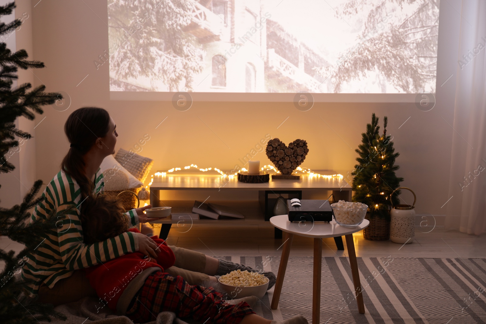 Photo of Mother and son watching Christmas movie via video projector at home