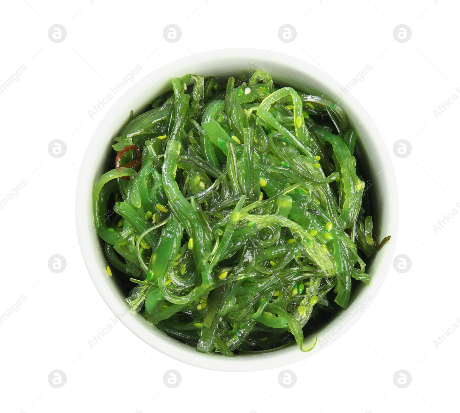 Photo of Japanese seaweed salad in bowl isolated on white, top view