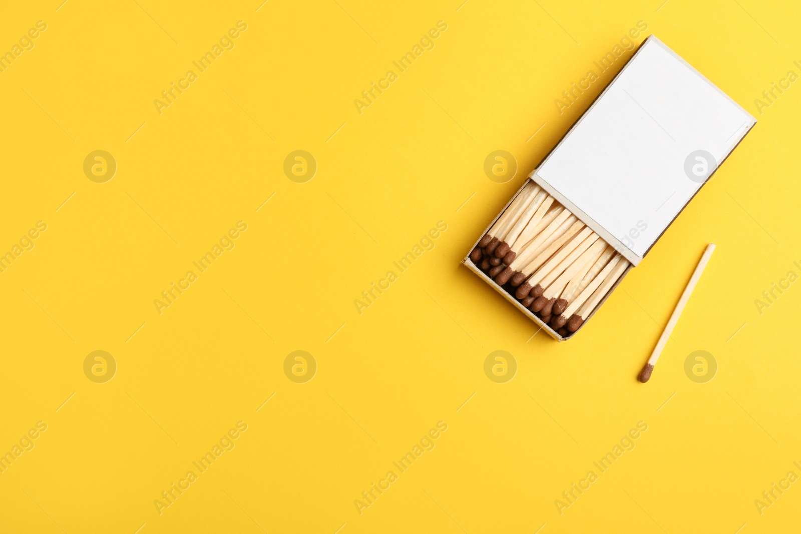 Photo of Cardboard box with matches on color background, flat lay. Space for text