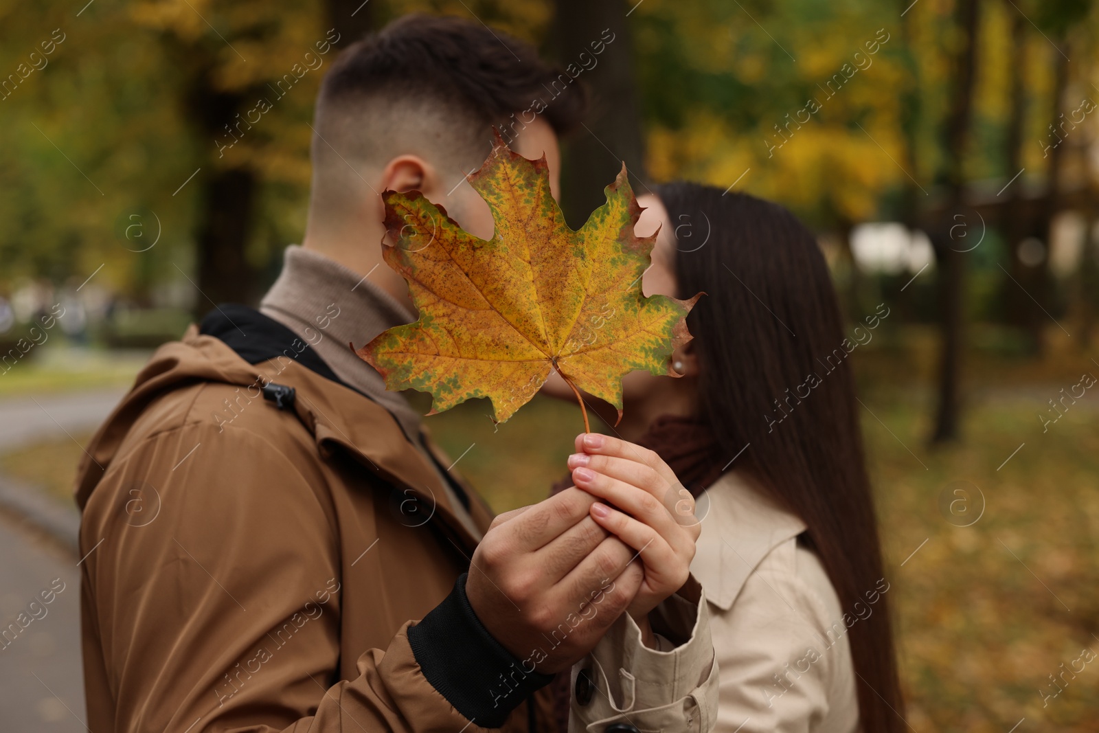 Photo of Romantic couple with dry leaf in autumn park