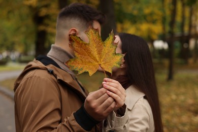 Photo of Romantic couple with dry leaf in autumn park