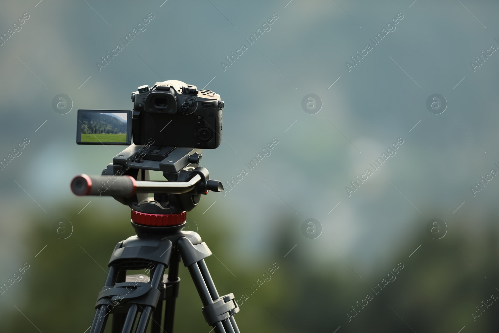 Photo of Taking photo of beautiful landscape with camera mounted on tripod outdoors, space for text