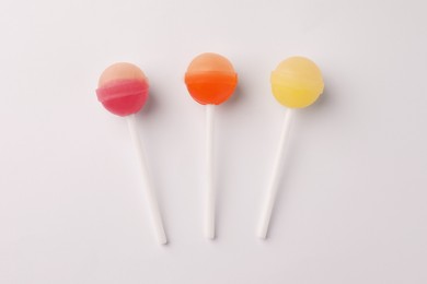 Photo of Tasty lollipops on white background, flat lay