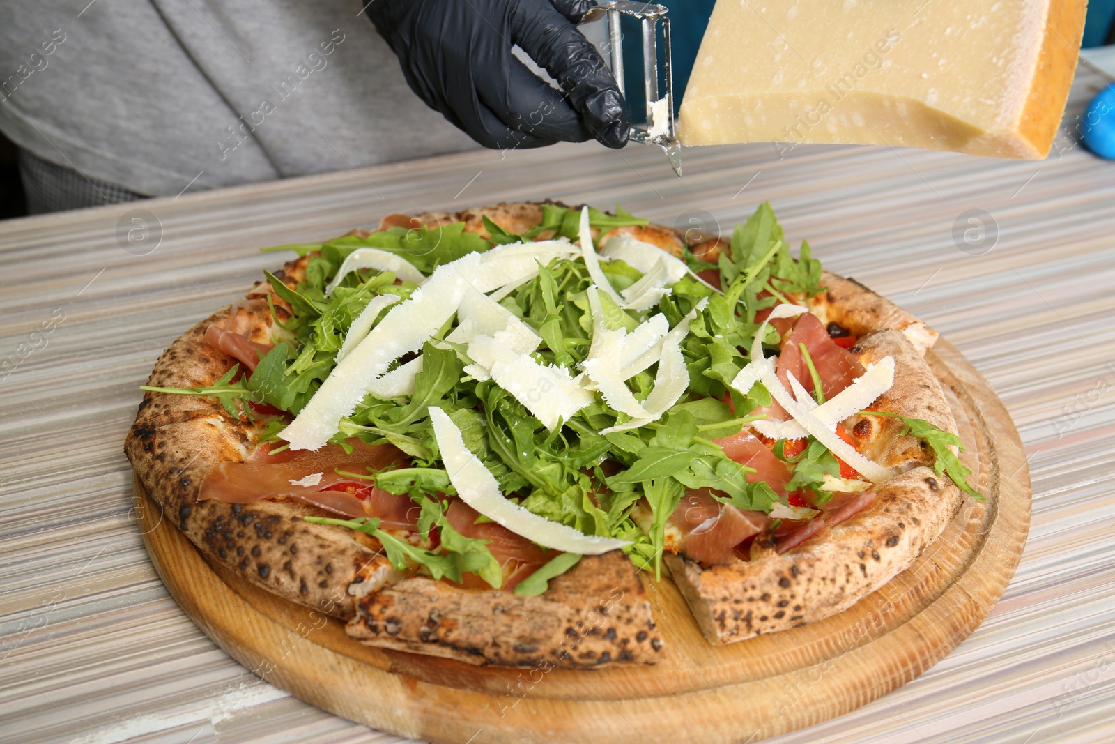 Photo of Professional chef preparing Italian oven baked pizza in restaurant, closeup