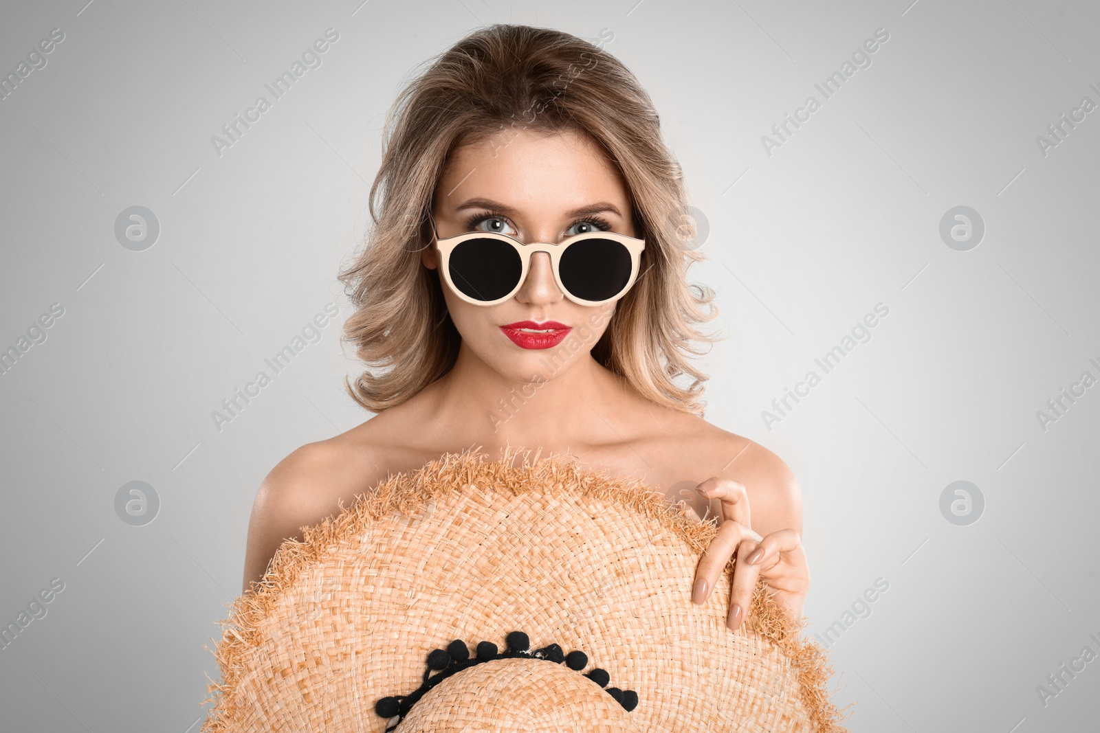 Photo of Young woman wearing stylish sunglasses on light grey background