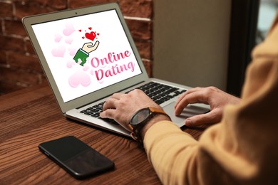 Image of Man visiting dating site via laptop at wooden table indoors, closeup