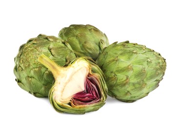 Cut and whole fresh artichokes on white background