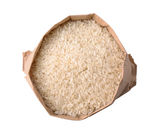 Photo of Uncooked rice in paper bag isolated on white, top view