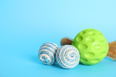 Photo of Pet toys and dog treat on light blue background, space for text