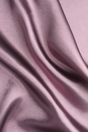 Crumpled dark purple silk fabric as background, top view