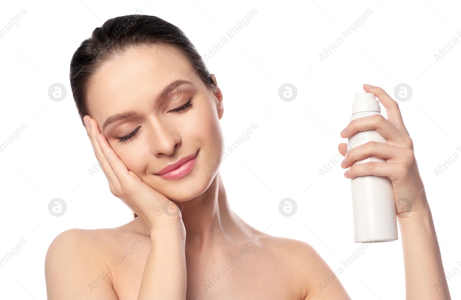 Photo of Young woman applying thermal water on face against white background. Cosmetic product