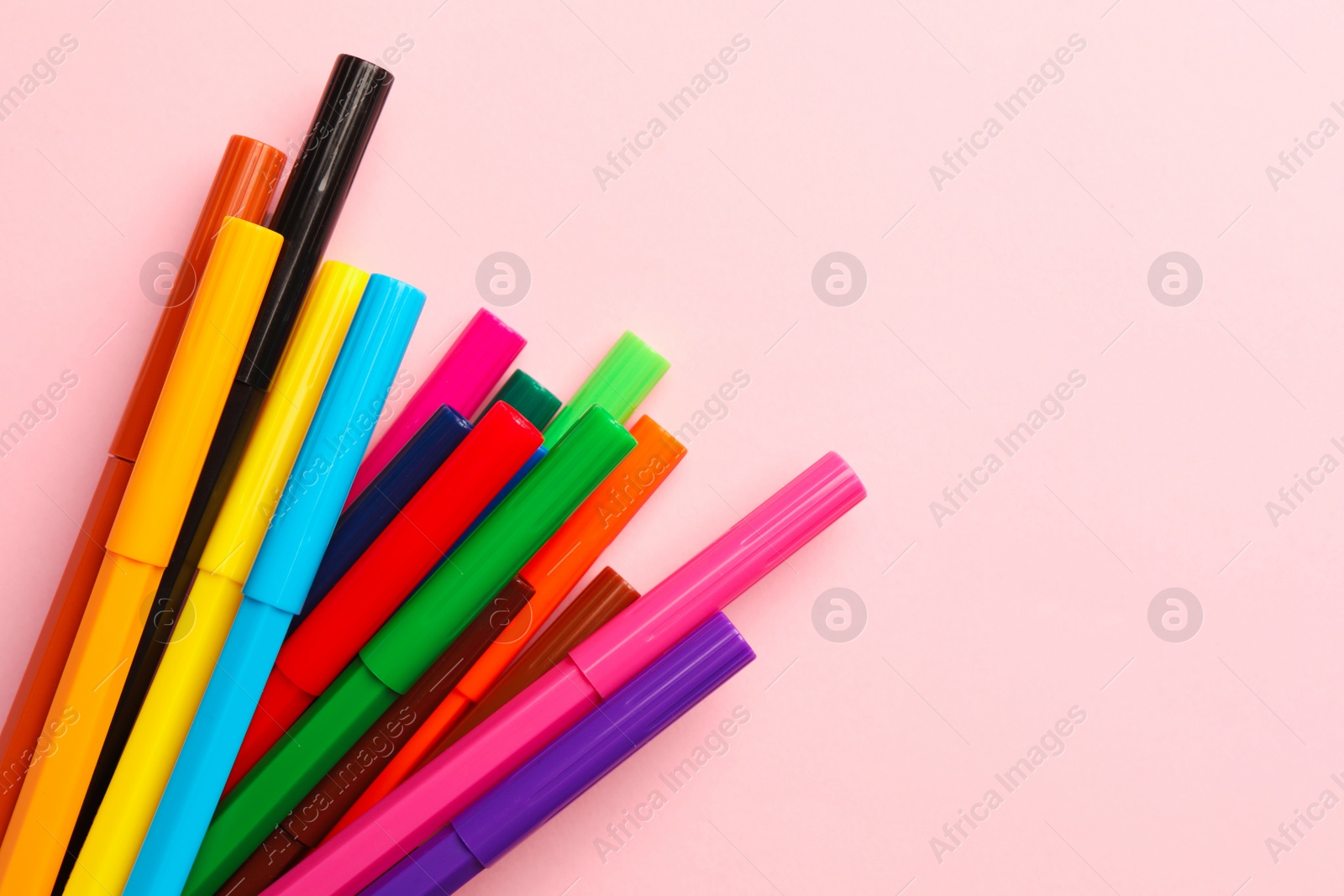 Photo of Many bright markers on pink background, flat lay. Space for text