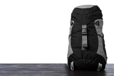 Photo of Hiking backpack on wooden surface against white background. Space for text