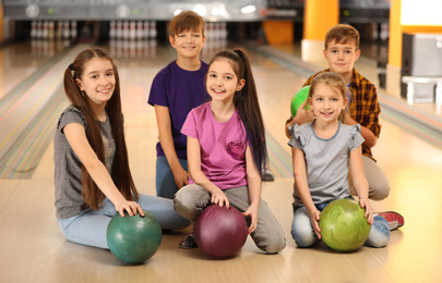 Photo of Happy children with balls in bowling club