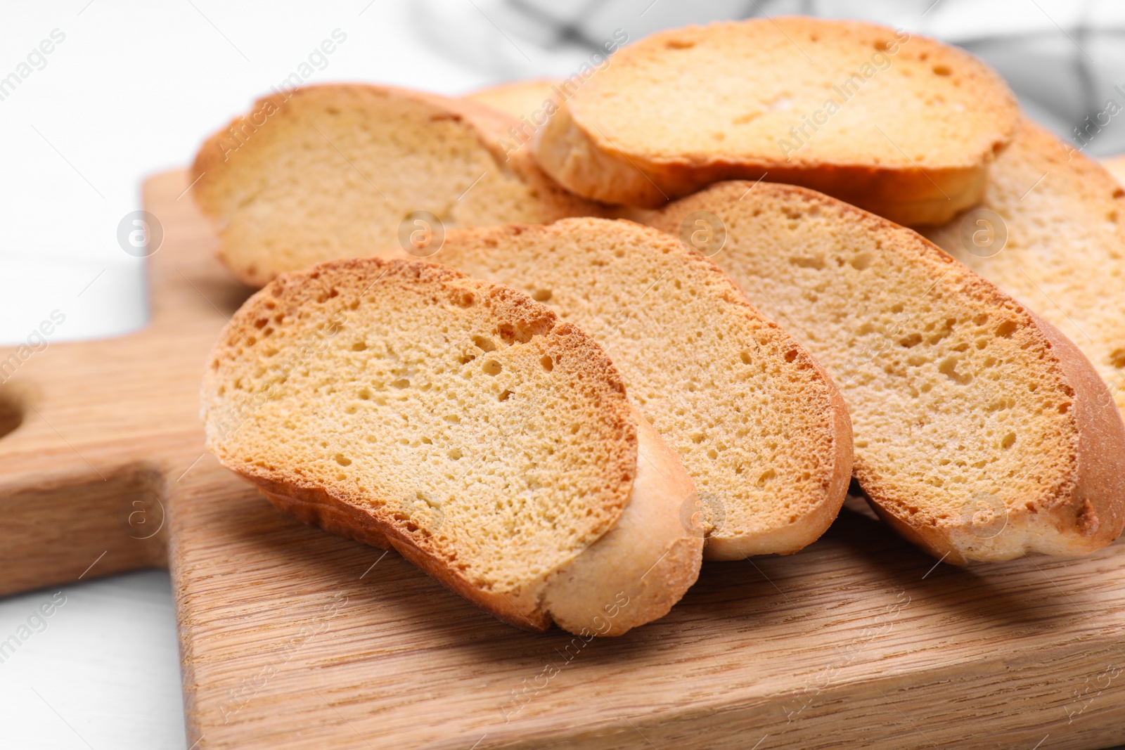 Photo of Tasty hard chuck crackers on white wooden table, closeup