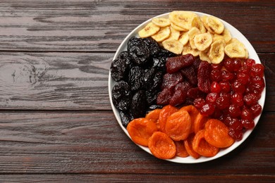 Delicious dried fruits on wooden table, top view. Space for text