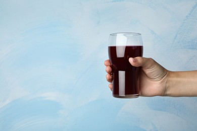 Image of Woman with glass of juice on light blue, closeup. Space for text 